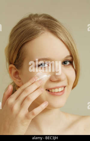 Teenage girl creaming face. Stock Photo