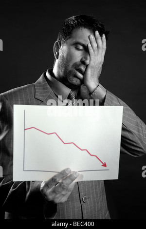 Businessman with bad sales reports chart. Crisis Stock Photo