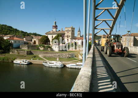 A tractor crosses the bridge over the River Lot at castelmoron, Aquitaine, France Stock Photo