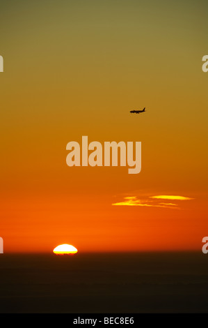 Airplane approaching Gatwick Airport at sunrise; view from Pitch Hill, Surrey. Stock Photo