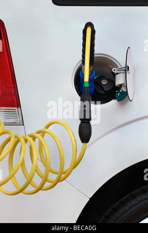 Refueling gas with a nozzle and hose on a car, besides the normal tank cap Stock Photo