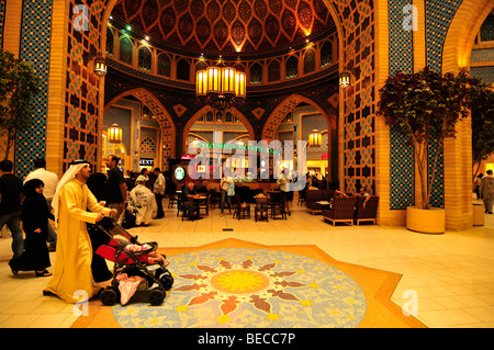 Shopping tourists in front of an elaborately decorated arch in the Persian part of the Ibn Battuta Mall, Dubai, United Arab Emi Stock Photo