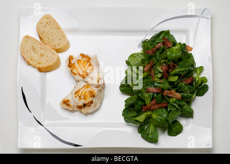 Sea-Devil fish (Lophius piscatorius) and field salad (Valerianella locusta) with roasted bacon strips and baguette bread