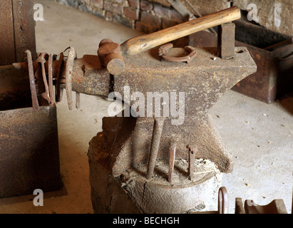 Old anvil and tools in a forge at Cressing Temple Barns Essex England Stock Photo