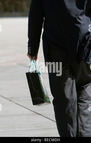 Rear view of a businessman carrying a shopping bag Stock Photo