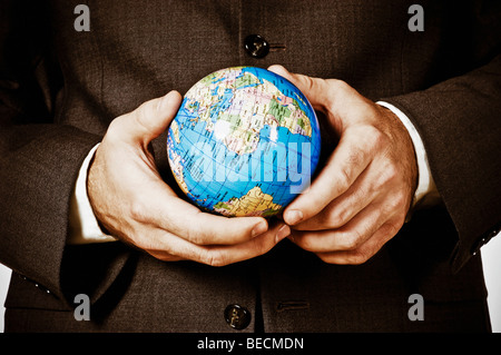 Mid section view of a businessman holding a globe Stock Photo
