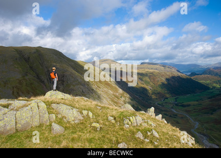 Lady fell walker looking at the view from Seathwaite Fell towards Borrowdale and Derwent Water. Stock Photo