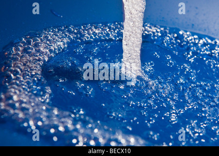 Water flowing into a basin, air bubbles Stock Photo
