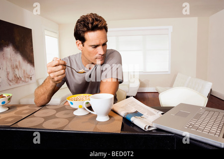 Man having breakfast and reading a newspaper Stock Photo
