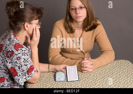 Teenage girl and her mom discussing money matters. Stock Photo