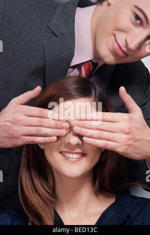 Man covering a woman's eyes and smiling Stock Photo