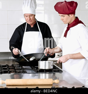 Two chefs cooking food in the kitchen Stock Photo