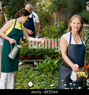 Two women with a man working in a garden Stock Photo