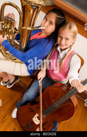 Portrait of two girls playing violin and tuba in a class Stock Photo
