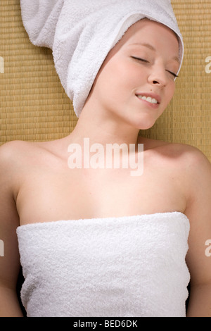 Young woman relaxing in a spa, towel wrapped around her head Stock Photo