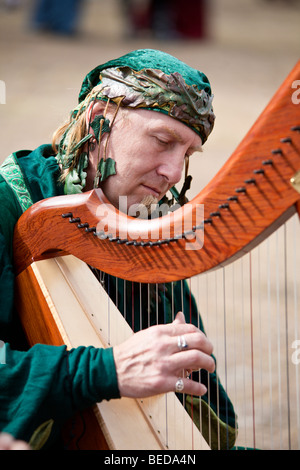 Male harpist plays at Renaissance Faire in Central Florida, USA Stock Photo