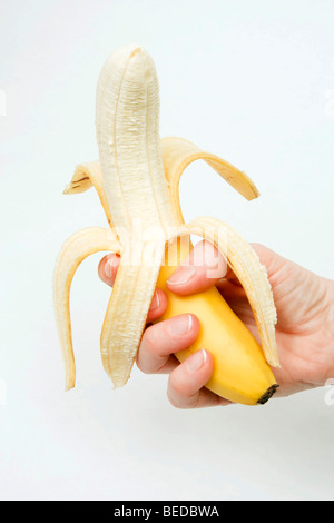 Peeled banana in hand Stock Photo