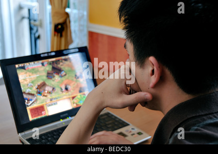 Young Asian Man Looking at Laptop Computer, Screen Over Shoulder, From Behind, Alone at Home, Chinese Student, people on laptops, young person laptop Stock Photo