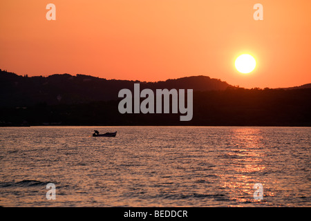 fisherman in his boat at sunset, Corfu, Greece Stock Photo