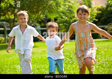 THREE CHILDS RUNNING Stock Photo