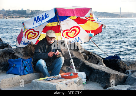 Turkish fisherman in Istanul preparing lines and weights beside the Bosphorus. Stock Photo