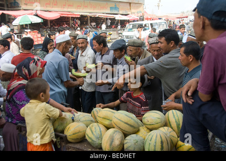 people buying fresh melons in a market of Kashgar, Xinjiang Province, China. Stock Photo