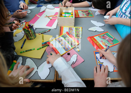 CHILDREN DRAWING ON CUT OUT BUTTERFLIES AT A SUNDAY SCHOOL UK