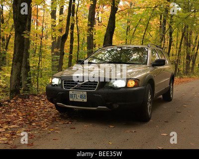 Volvo XC70 on a country road in fall nature scenery. Stock Photo