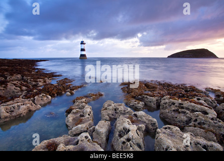 A view of Penmon Lighthouse and Puffin Island at dawn on the coast of Anglesey in North Wales. Stock Photo