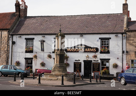 Warkworth, Northumberland, England, UK. Old Masons Arms pub and Market Cross in the village centre Stock Photo