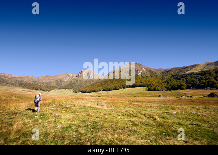 A lone hiker in the glacial valley of the 'Fontaine salée' (Puy de Dôme). Randonneur dans la vallée de la Fontaine Salée. Stock Photo