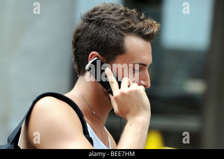 Portrait of young man using a mobile phone in Piazza del Duomo Milan Italy He looks thoughtful and intent as though listening Stock Photo