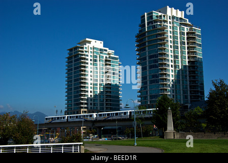 Elevated rail light rapid transit commuter train system running by high rise residential towers at east end of False Creek Stock Photo