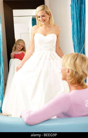 Bride trying on wedding dress with sales assistant Stock Photo