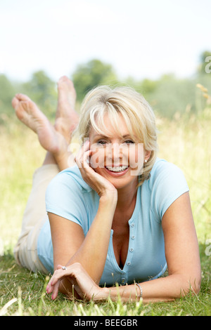 Portrait of mature woman relaxing in countryside Stock Photo
