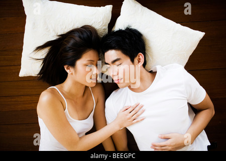 Asian Young couple lying on floor sleeping Stock Photo