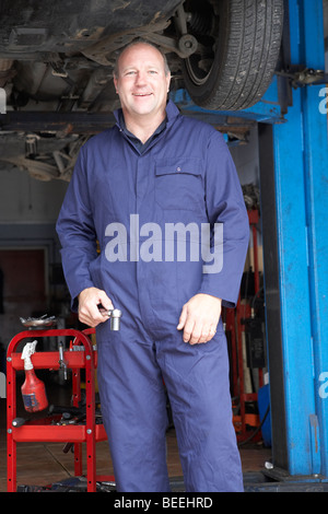 Auto mechanic working on a car wheel in a garage Stock Photo - Alamy