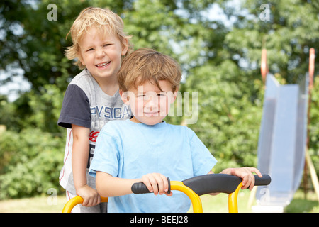 Two Young Boys Playing on Bike Stock Photo