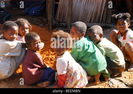 Madagascar - Children help to mix clay to make a fuel efficient stove at Ebakika Village. Stock Photo