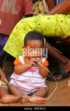 Madagascar - Teething child chewing a reed at Ebakika Village Stock Photo