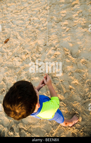 Young boy flying a kite on the beach Stock Photo