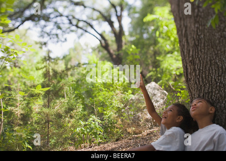 Boy and girl sitting under the tree Stock Photo - Alamy