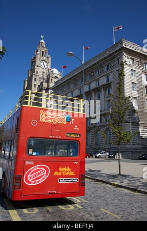 red sightseeing liverpool tour bus on canada boulevard in front of the the cunard building one of liverpools three graces Stock Photo