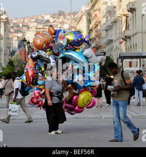 Street traders on Aristotelous Square Thessaloniki Greece. Woman selling balloons the man sells CD's DVD's Stock Photo