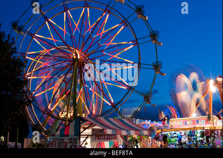 Evergreen State Fair at twilight with Ferris Wheel and amusement rides and game booths at night Monroe Washington State USA Stock Photo