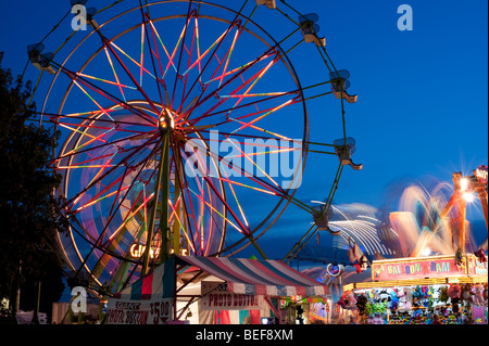 Evergreen State Fair at twilight with Ferris Wheel and amusement rides and game booths at night Monroe Washington State USA Stock Photo