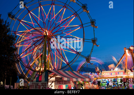 Evergreen State Fair at twilight with Ferris Wheel and amusement rides and game booths at night Monroe Washington State USA Stock Photo