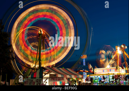 Evergreen State Fair at twilight with Ferris Wheel and amusement rides and game booths at night Monroe Washington State USA Stock Photo