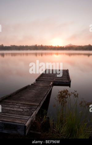 Sunrise at Lake Cassidy in fog with Mount Pilchuck and dock in foreground Stock Photo