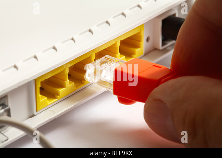 Ethernet cable plugging into broadband modem. Stock Photo